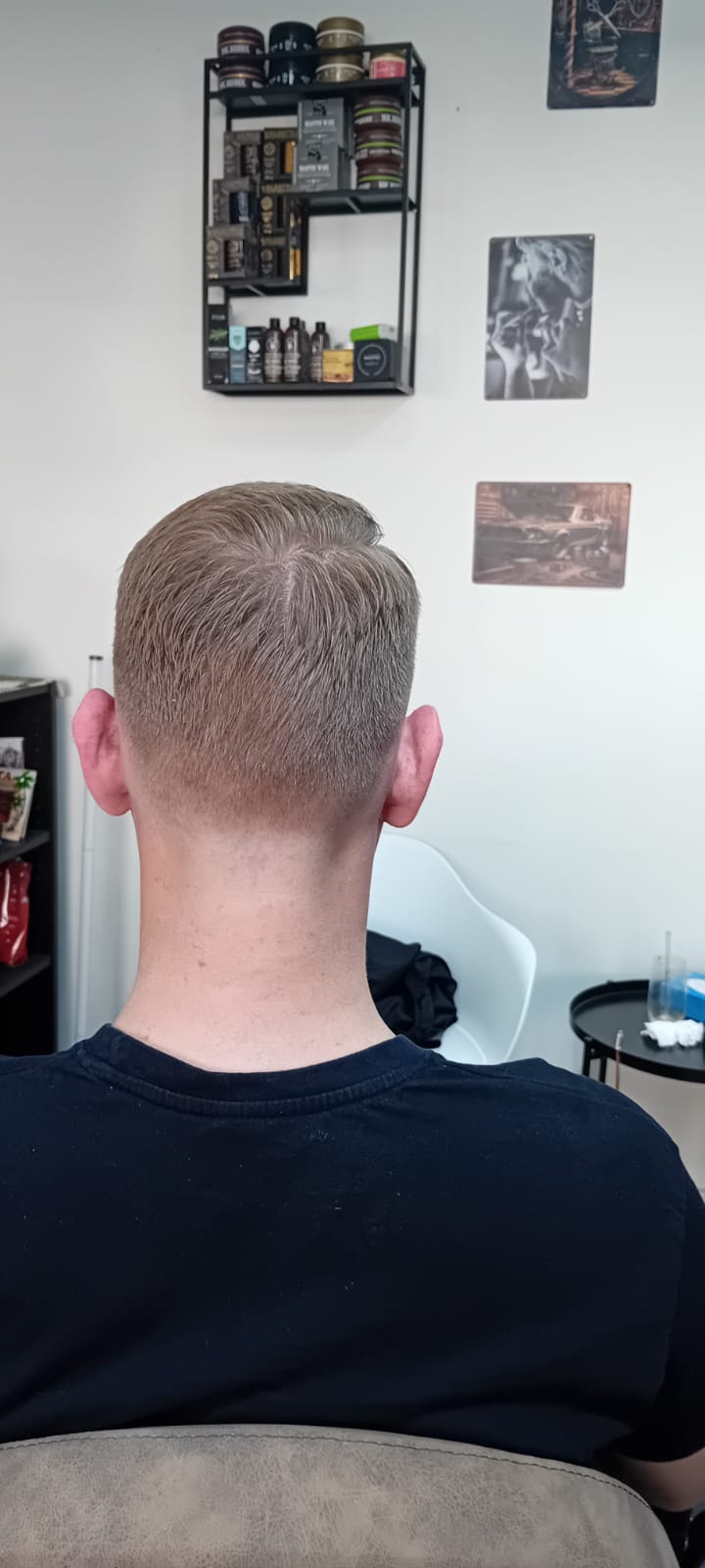 High skin fade frisure på klient med blondt hår - herrefrisure set fra bagfra