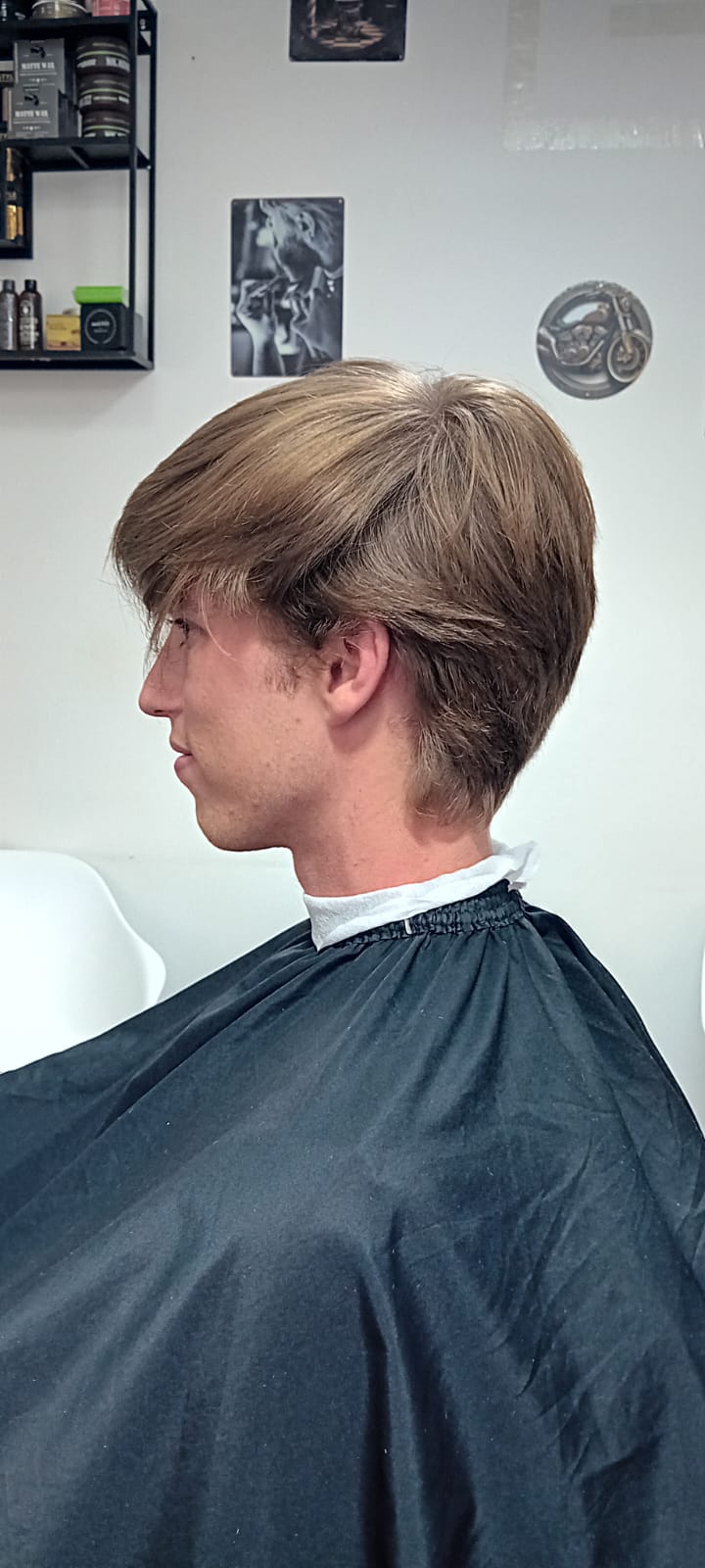 Før slick back frisure med low fade i siderne på klient med blondt hår - herrefrisure set fra venstre
