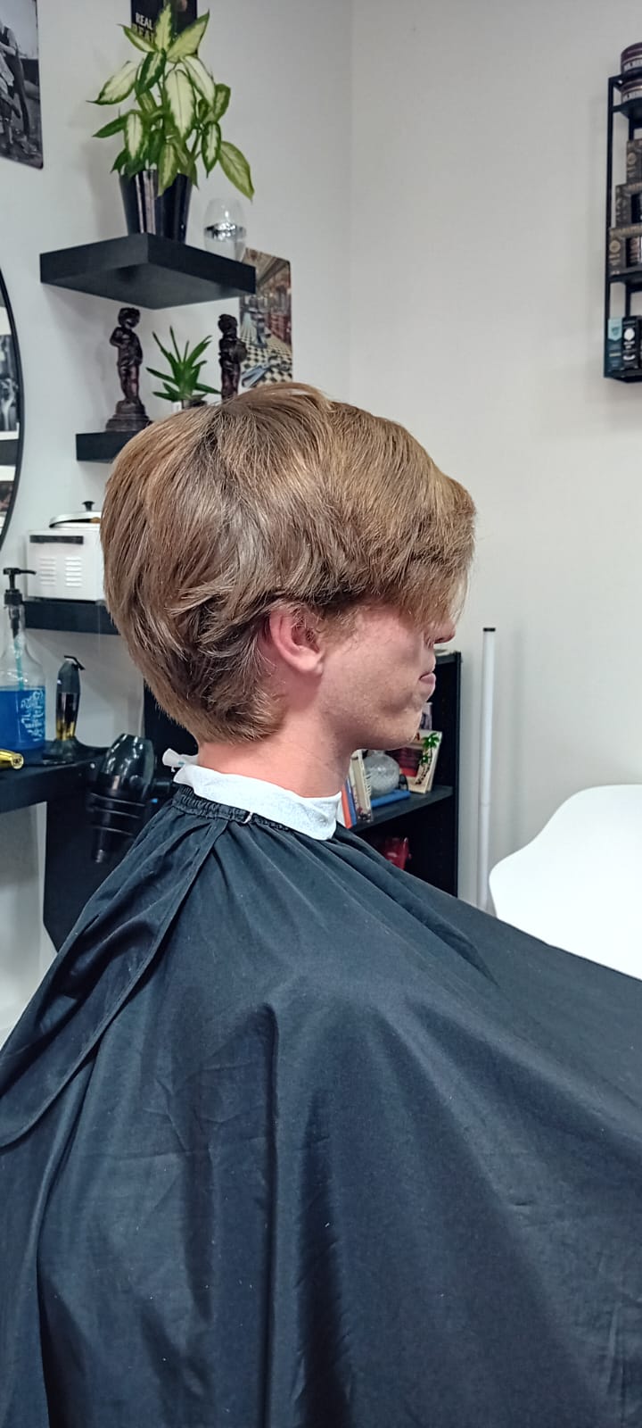 Før slick back frisure med low fade i siderne på klient med blondt hår - herrefrisure set fra højre